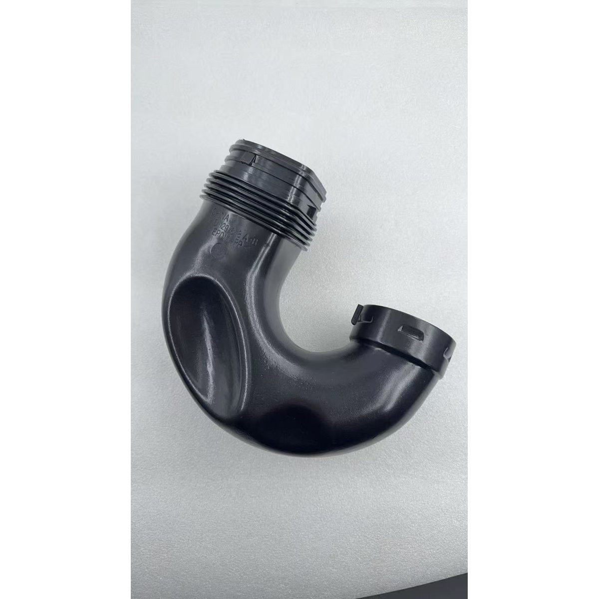Black plastic air intake duct elbow with ribbed coupler and latch tab