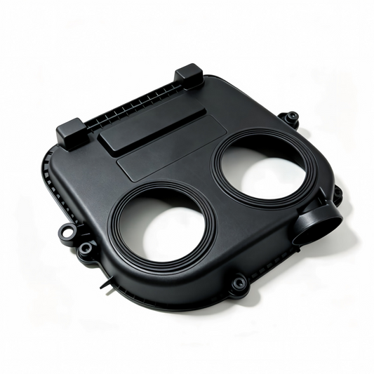 Black timing belt cover with two circular openings and mounting tabs