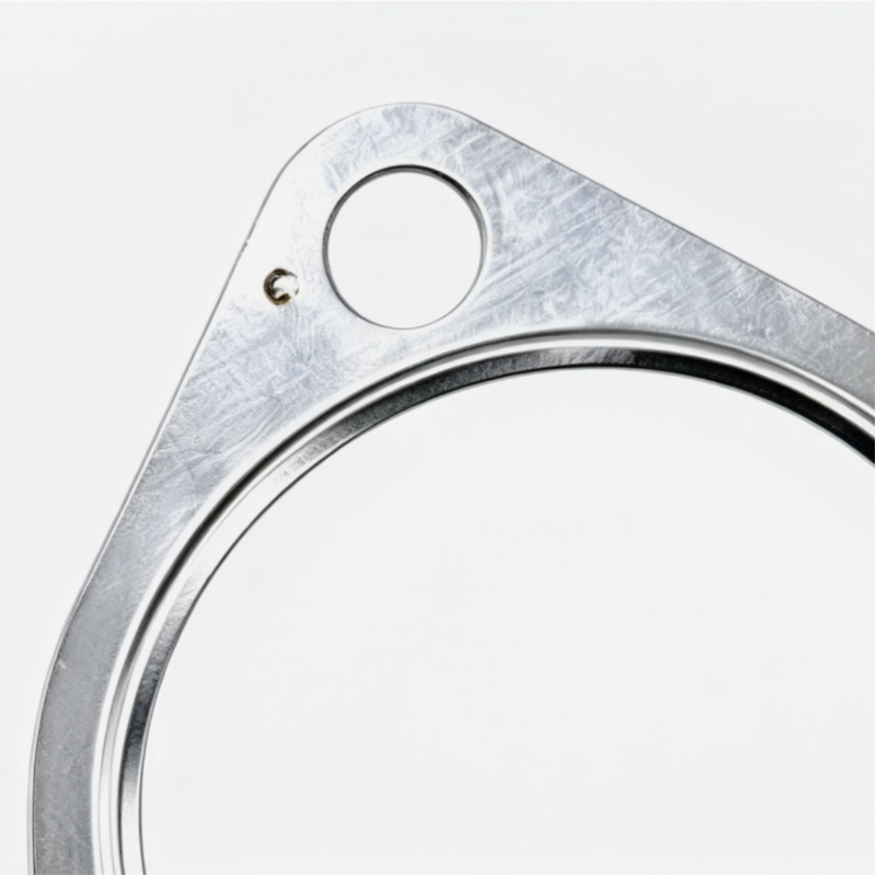 Exhaust gasket with triangular metal plate, circular sealing ring, and two bolt holes