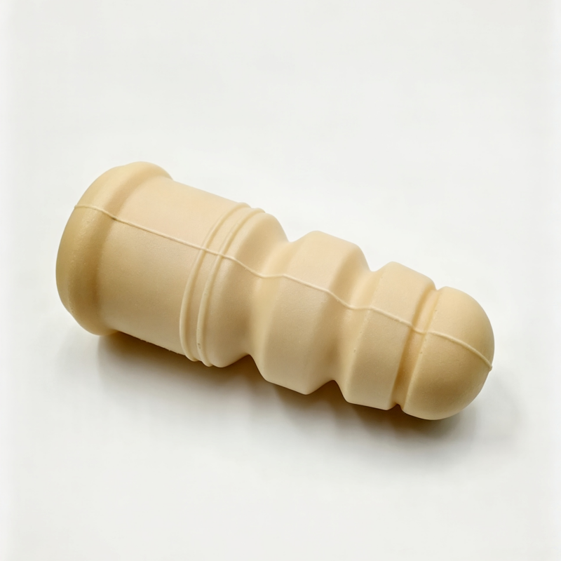 Rear shock absorber bump stop, beige rubber with stepped ridges and rounded capped end