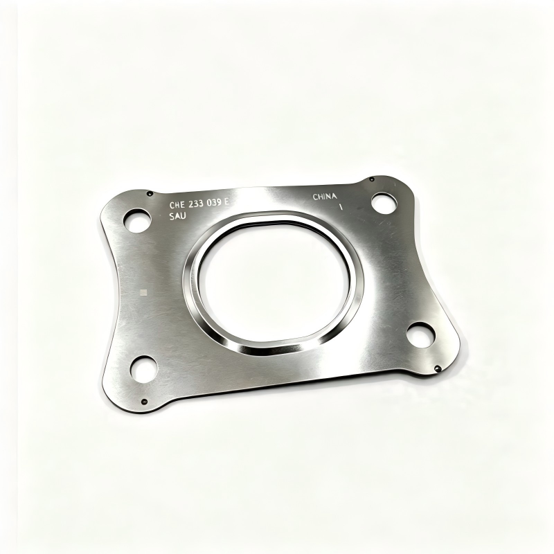 Exhaust manifold gasket, silver plate with circular opening, four bolt holes, stamped code.