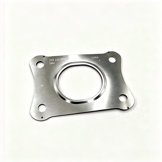 Exhaust manifold gasket, silver plate with circular opening, four bolt holes, stamped code.